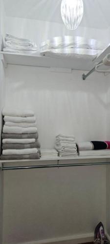 a shelf with some white towels and a light at Tim Pappies Nature Lodge - Alex's Place in Port Antonio