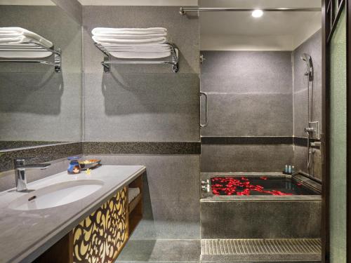 a bathroom with a sink and a shower with a red object at Riyuegu Hotsprings Resort in Xiamen