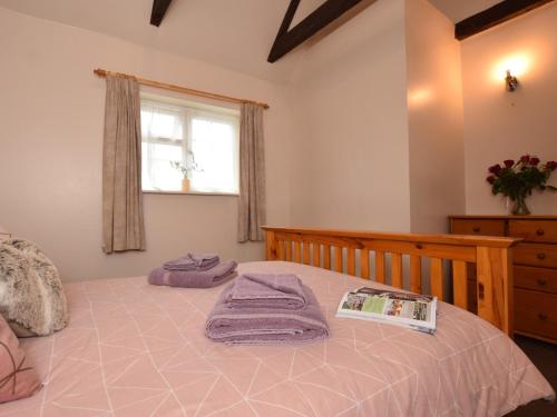 ハイブリッジにある1 bed in Burnham-on-Sea ALOLDのベッドルーム1室(紫色のタオルが付いたベッド1台付)