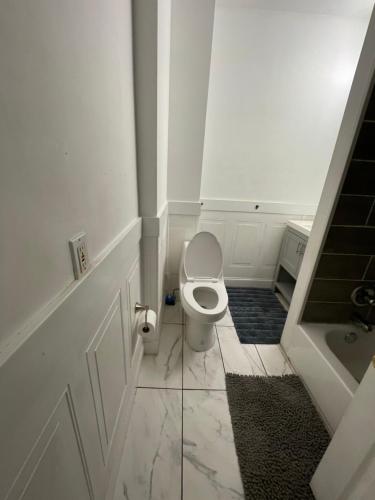 a white bathroom with a toilet and a sink at Point Breeze South Philly (2 bedrooms) in Philadelphia