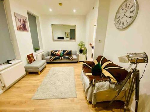 a living room with a couch and a clock on the wall at London Bridge Beauty Luxury 2bed 2bath in London