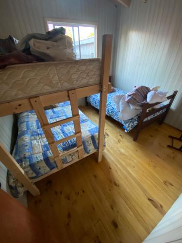 1 dormitorio con 2 literas y suelo de madera en Cabañas-La vara senda sur, en La Chamiza