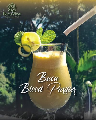 a glass of blood punch with a lemon and a straw at Bucu View Resort in Ubud