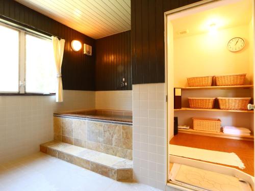 Baño con ducha a ras de suelo junto a una ventana en Kiyosatokogen Country Inn The Classic, en Hokuto