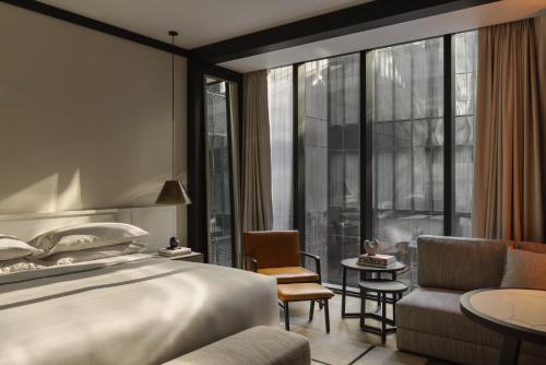 a hotel room with a bed and a large window at Capella Sydney in Sydney