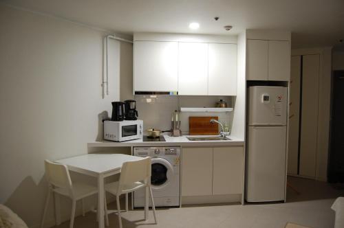 a small kitchen with a table and a white refrigerator at Newly Renovated House in Yatap-dong in Seongnam