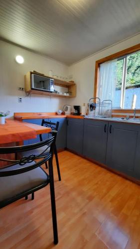 een keuken met een tafel en stoelen in een kamer bij Lafken Lodge in Villarrica