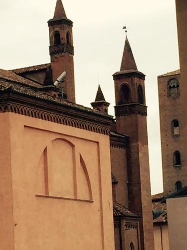 a building with a sign in front of two towers at Albergo San Lorenzo in Alba