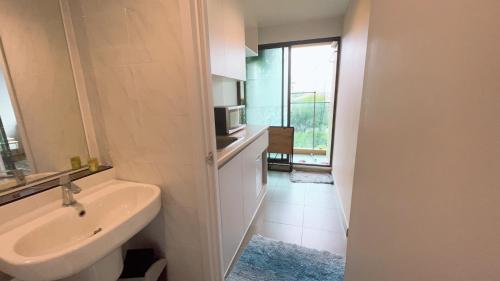 a white bathroom with a sink and a microwave at Resort Style Condo Suksawat 64 Bangkok ND in Ban Tha Hin