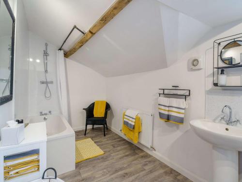 een witte badkamer met een wastafel en een bad bij 2 Bed in Cockermouth 85680 in Bridekirk