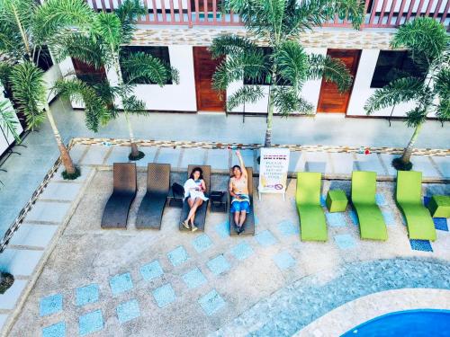 zwei Frauen auf Stühlen neben einem Pool in der Unterkunft Mountain View Garden Inn Coron in Coron