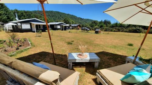 een patio met stoelen, een parasol en een tafel bij Lafken Lodge in Villarrica