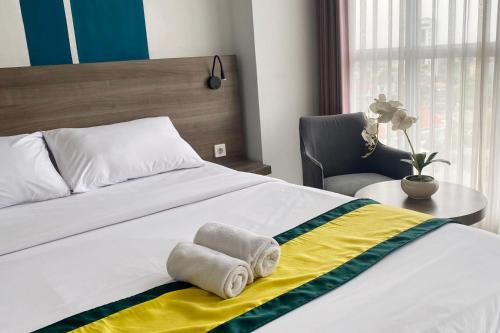 a bedroom with a bed with towels on it at Hotel Dhika Serenity Surabaya in Surabaya