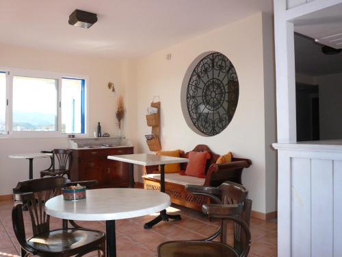 Hotel Mayarí في كالاباردينا: غرفة معيشة مع طاولات وكراسي وأريكة