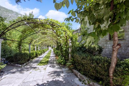 a garden with an arbor and a pathway at Villa D'amore Montenegro in Donji Morinj