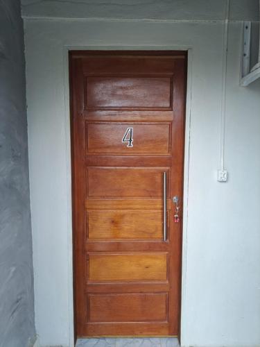 eine Holztür mit der Nummer drauf in der Unterkunft AP 4 - Apartamento Espaçoso, Confortável e Aconchegante - Pousada Paraíso in Macapá