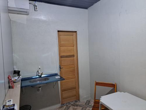 una pequeña cocina con fregadero y puerta en AP 4 - Apartamento Espaçoso, Confortável e Aconchegante - Pousada Paraíso, en Macapá