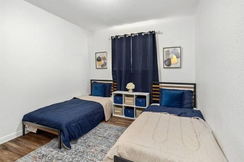- une chambre avec 2 lits et un rideau bleu dans l'établissement SAT Airport, 4 BdRms, Large Group, Wheelchair, à San Antonio
