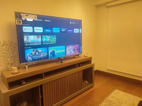 una grande TV a schermo piatto seduta su un supporto di Apartamento entero en el más importante centro financiero, bursátil, San Isidro, Lima, Peru a Lima