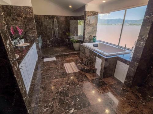 a large bathroom with a tub and a sink at Palacio Pura Vibra in Ciudad Cariari