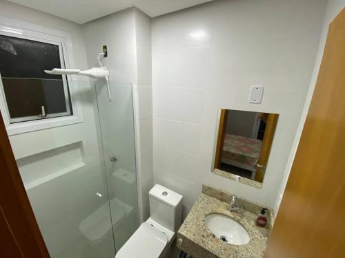a bathroom with a toilet and a sink and a shower at Ótimo Ap a 50m da areia Churrasq 2Q 2banheiros in Torres