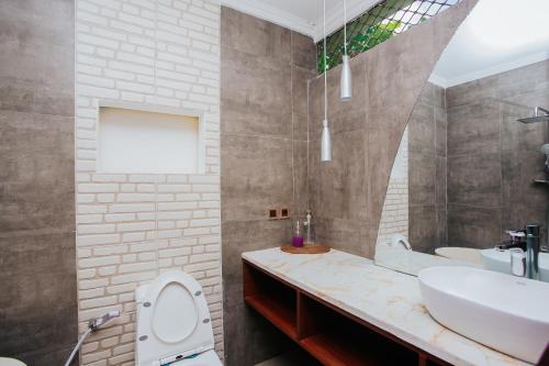 a bathroom with a sink and a toilet and a mirror at Medana Bay Marina in Paloh