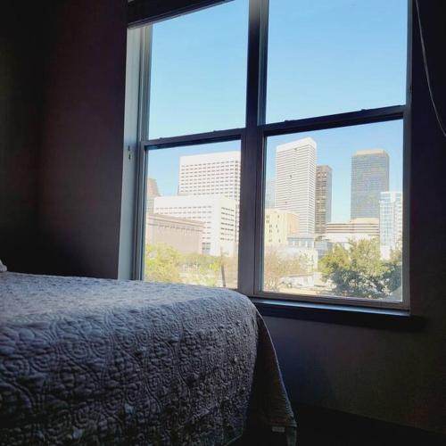 a bedroom with a view of a city from a window at Downtown Dream Toyota Ctr/George R Brown/Minute Maid Stadium in Houston