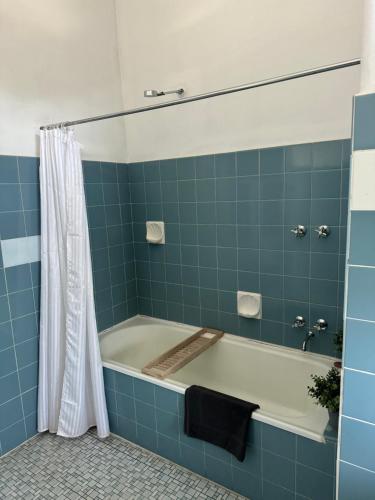 a blue tiled bathroom with a bath tub at Thommos Pub in Cobden