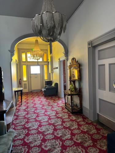 a living room with a red carpet and a chandelier at Thommos Pub in Cobden