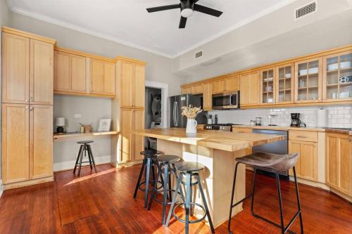 a large kitchen with wooden cabinets and bar stools at Reduced! Casa Paz - Historic Home Walking Distance in San Antonio