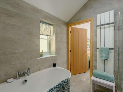 uma casa de banho com uma banheira e uma janela em 2 Bed in Lixwm 88028 em Nannerch