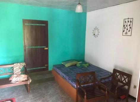 a room with a bed and two chairs in it at Vintage River View Villa in Panadura