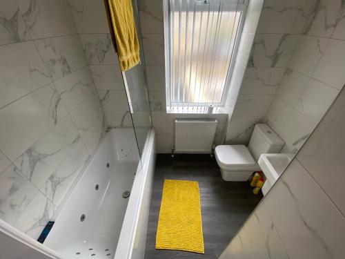 uma casa de banho com uma banheira, um lavatório e um WC. em Entire Southgate House em Elland