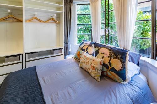 a bedroom with a bed with pillows and a window at Oversized Potts Point Studio in Sydney