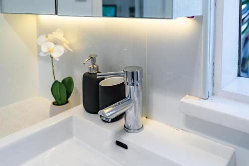 a bathroom sink with a faucet and a flower at Oversized Potts Point Studio in Sydney