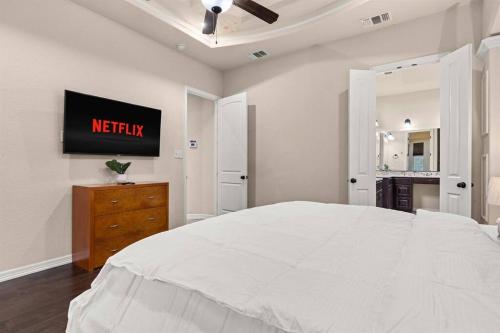 a white bedroom with a bed and a clock on the wall at Reduced! Randolph Central, 1-story, Chef Kitchen in Selma