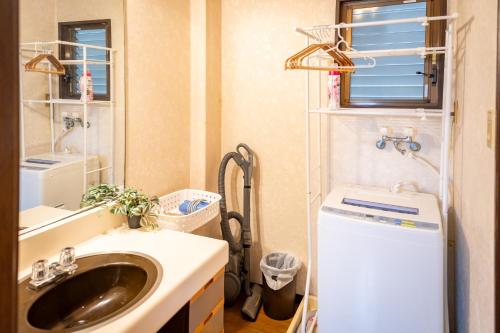 a bathroom with a sink and a washing machine at 大阪市東成区一軒家貸し切りファミリー向け小型車のみ無料駐車場可Private for families, small car free parking独栋可停小车 in Osaka