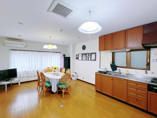 a kitchen with a table and chairs in a kitchen at 大阪市東成区一軒家貸し切りファミリー向け小型車のみ無料駐車場可Private for families, small car free parking独栋可停小车 in Osaka