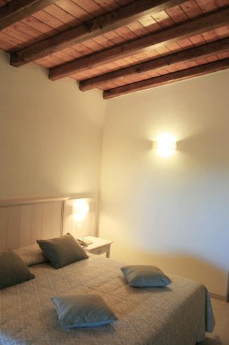 a bedroom with two beds and a table on a wall at Hotel Marana in Golfo Aranci