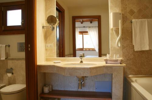 a bathroom with a sink, toilet and tub at Hotel Marana in Golfo Aranci