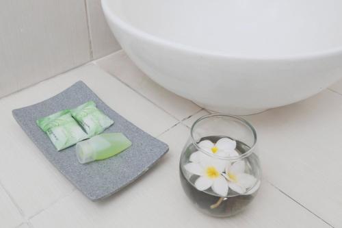 فندق سينجكارينج ترانسيت في تانغيرانغ: حمام مع مرحاض و مزهرية مع الزهور