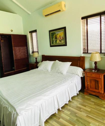 a bedroom with a large bed with white sheets at An Hoa Residence in Long Hai