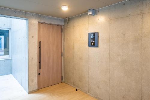uma porta num quarto com uma parede em REPURE OMORI RESIDENCE em Tóquio