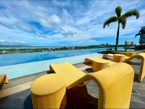 - un groupe de chaises jaunes et une piscine dans l'établissement Condo in Mactan Newtown with pool and beach access, à Mactan