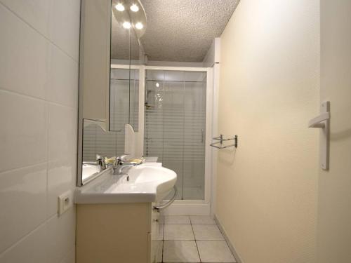 une salle de bain blanche avec un lavabo et une douche dans l'établissement Appartement T3 à Arcachon - Ville d'Hiver, proche centre et plage, avec terrasse et parking privé. - FR-1-433-113, à Arcachon