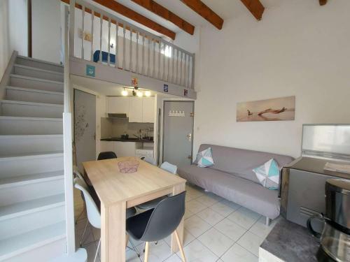 Cette petite chambre comprend une table et un lit. dans l'établissement Appartement 2 pièces meublé avec mezzanine et terrasse, accès direct à la plage, parking inclus - FR-1-326-798, à Marseillan