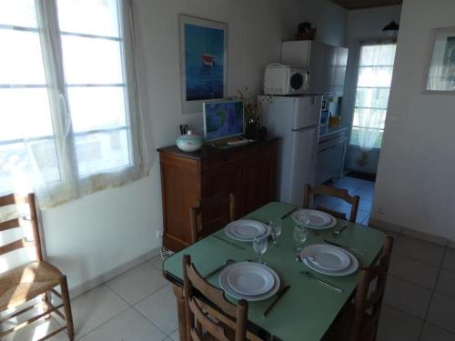 une cuisine avec une table avec des assiettes dessus dans l'établissement Maison près de la plage avec jardin et vélos, animaux bienvenus, équipée pour 4 personnes - FR-1-540-282, à Notre-Dame-de-Monts