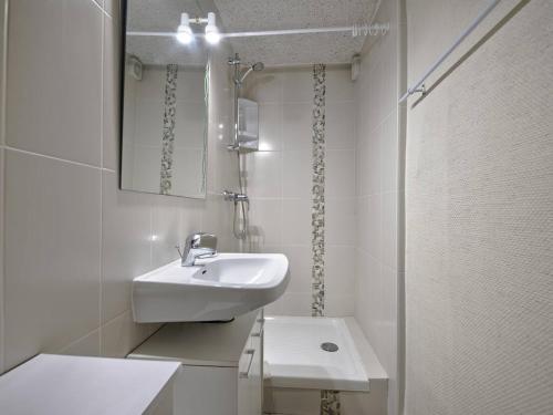 une salle de bain blanche avec un lavabo et un miroir dans l'établissement Charmant T2 en rez-de-jardin à 800m du centre-ville d'Arcachon, terrasse et parking inclus - FR-1-433-112, à Arcachon