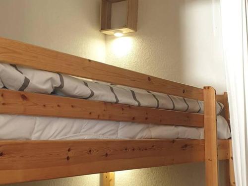 - un lit superposé en bois avec des draps blancs et une lampe dans l'établissement Studio Cabine à Giens avec Terrasse, Piscine et Parking - FR-1-335-193, à Hyères