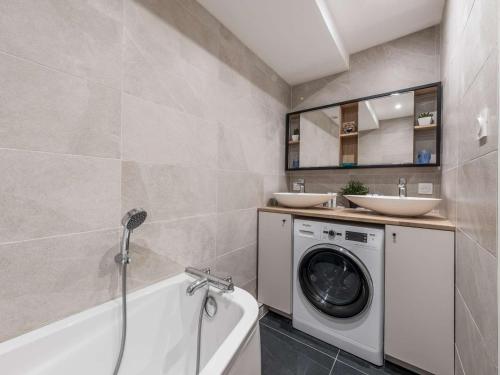 une salle de bain avec une machine à laver et un lavabo dans l'établissement Courchevel 1850 - 55 m² - 4 pers - skis aux pieds - parking - FR-1-631-184, à Courchevel